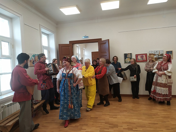 Фольклорная программа музейного коллектива. Группа людей танцует и играет на музыкальных инструментах.