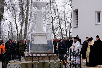 Лития на могиле А. С. Пушкина. На переднем плане священник в белой рясе. За ним стоит группа людей.